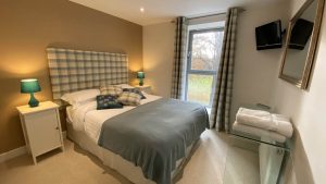 The master bedroom is welcoming and warm with views to the cricket pitch